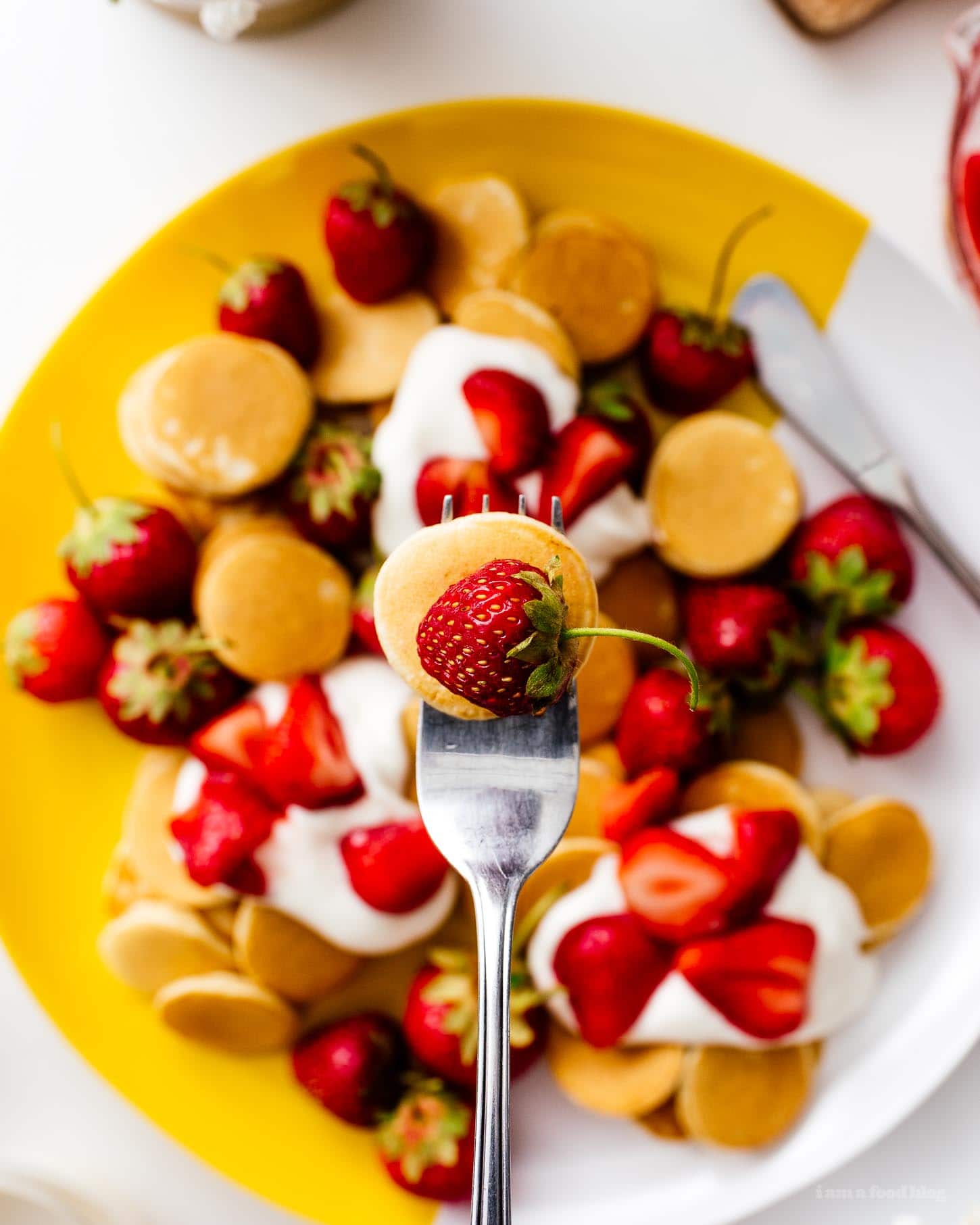 This fluffy mini strawberry shortcake pancake recipe is perfect for summer. Super cute mini silver dollar vanilla pancakes topped with juicy strawberries and softly whipped cream. Like a strawberry shortcake for breakfast! #strawberries #strawberry #strawberrypancakes #strawberrypancake #strawberryshortcake #strawberryshortcakes